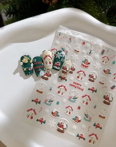 Détail de stickers à ongles 3D de Noël avec Père Noël et motifs festifs sur plateau