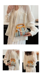 Detail of colorful striped woven handbag featuring round wooden handle and pearl strap