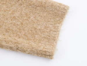Dettaglio del tessuto a maglia in peluche color cammello con fibre lunghe e soffici texture