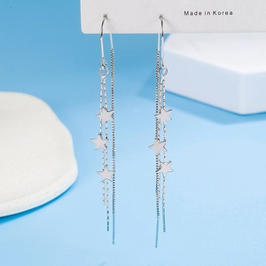 Polished silver star tassel earrings with long chain dangles on light blue background