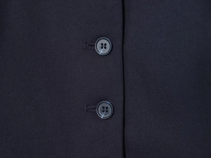 Detailaufnahme von schwarzem Kleiderstoff mit parallelen Rundknöpfen und feiner Twill-Textur