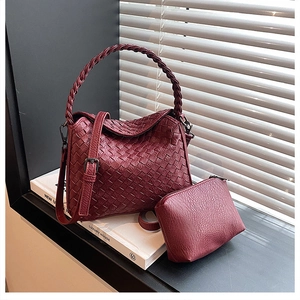 Detail of wine red woven texture handbag with matching zipper pouch and round handle