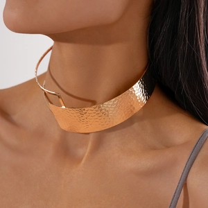 Detailed close-up of rose gold textured metal choker with hammered industrial finish