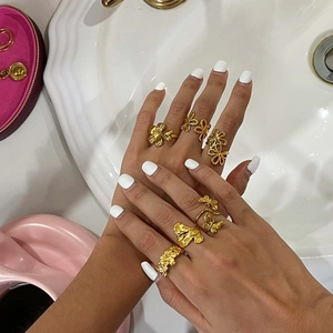 Close-up of assorted 18K gold-plated stainless steel flower and butterfly open rings