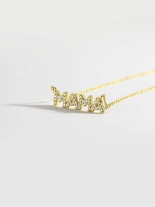 Detailed close-up of a gold MAMA pendant necklace with sparkling micro-pave crystals