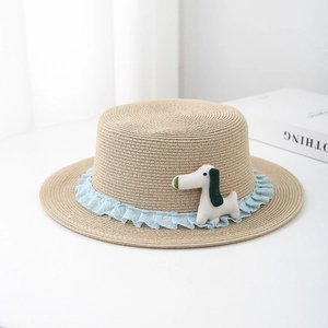 Detail of children's straw boater hat with light blue lace trim and a cute puppy doll