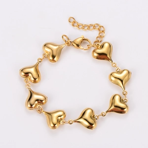 Detailed shot of a gold heart charm bracelet with an adjustable lobster clasp