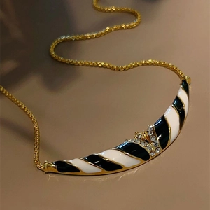 18K gold plated necklace featuring a black and white striped crescent pendant with rhinestones