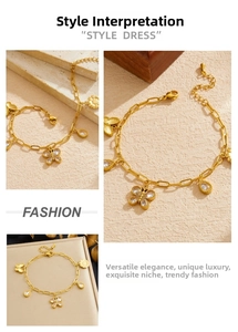 Detail of gold butterfly and sunflower charms on a layered stainless steel chain bracelet