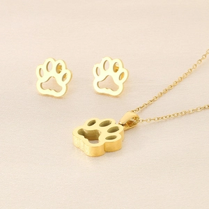 Détail d'un ensemble de bijoux pattes de chat dorés avec collier et boucles d'oreilles