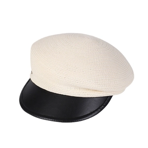 Asymmetric beige woven newsboy hat with a black leather brim for a minimalist fashion look
