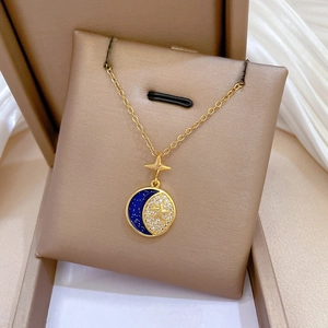 Detail of celestial pendant with blue enamel and crystal moon on gold chain
