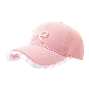 Pink baseball cap with pearl bow and white lace trim edge on soft cotton fabric