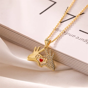 Close-up of gold plated MOM pendant with red heart and sparkling rhinestones