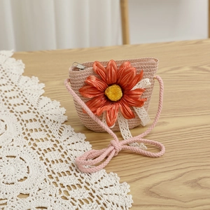 Vue détaillée du sac bandoulière en paille rose avec fleur et nœud en dentelle