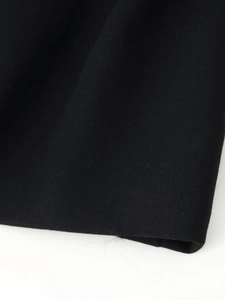 Gros plan sur la texture du tissu en suédine noire d'un manteau long d'hiver pour femme