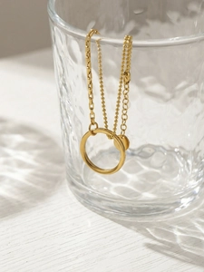 Detail of 18K gold plated double chain necklace with geometric circle charm on glass