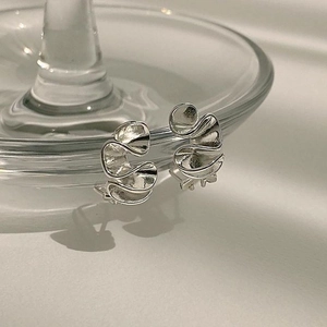 Macro view of abstract wavy sterling silver stud earrings with a polished mirror finish
