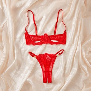 Flat lay of red floral lace lingerie set with adjustable straps on champagne satin fabric