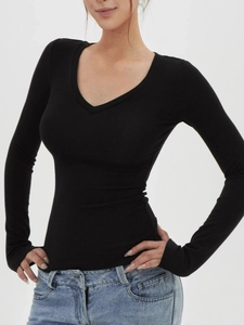 T-shirt noir moulant à manches longues avec col en V et jean bleu clair délavé