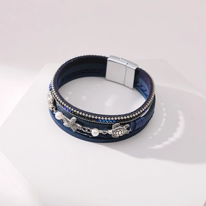 Detailed close-up of a multi-layer sea turtle bracelet with starfish and blue leather cords