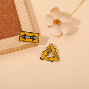 Dettaglio del set di spille smaltate gialle con scritte Choose Optimism e Keep
