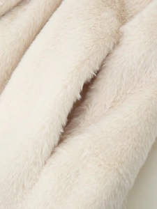 Close-up of soft beige faux fur texture with dense fluffy fibers and glossy finish