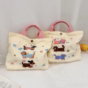 Détail de sacs à lunch en velours côtelé avec broderie animale et boutons-pression