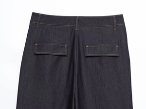 Détail du pantalon en jean bleu foncé avec coutures orange contrastées et poche arrière