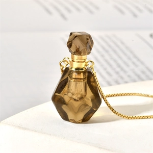 Macro shot of tea-colored crystal flame perfume bottle pendant with golden chain