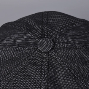 Top detail of dark gray pinstripe octagonal cap featuring central fabric button