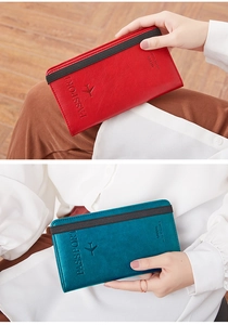 Detail of red and blue leather passport wallets with elastic strap and logo