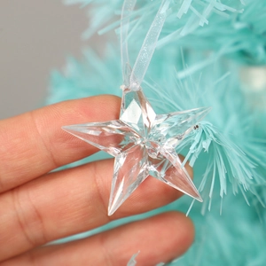 Transparent acrylic star ornament hanging on a Christmas tree for winter holiday decor