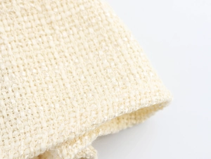 Detaillierte Makroaufnahme der beigen Tweed-Stofftextur und des Webmusters für Damenkleider