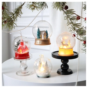 Detailed view of glowing Christmas LED glass ornaments with red house and elk inside