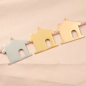 Detailed view of 35mm house-shaped hollow charms in silver, gold and rose gold steel
