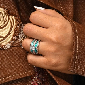 Detail of silver-tone ring with blue enamel, large round center stone and pave diamonds