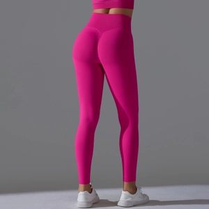 Detail of high-waisted rose red yoga pants with scrunch butt lifting effect on grey background