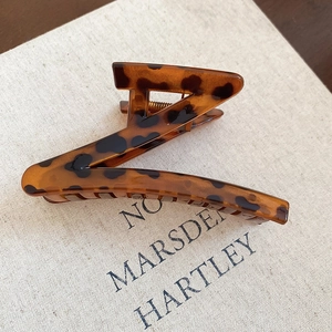 Detail view of large Z-shaped leopard print hair claw clip with strong metal spring