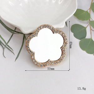 Detailed view of flower shaped vanity mirror with gold crystal trim, 49mm by 50mm