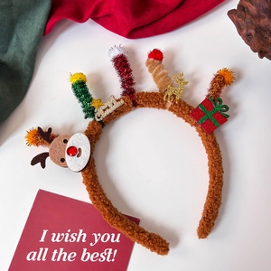 Detail of plush Christmas headband featuring reindeer, gift box, and Merry Christmas sign