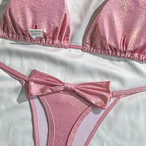 Flat lay of pink sequin bikini with metallic luster and detailed washing label view
