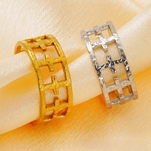 Macro shot of gold and silver hollow cross rings with unique hammered texture on silk