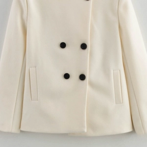 Elegant white double-breasted woolen coat for women with black button details and side pockets