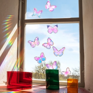 Close-up of holographic butterfly window stickers creating vibrant rainbow light reflections