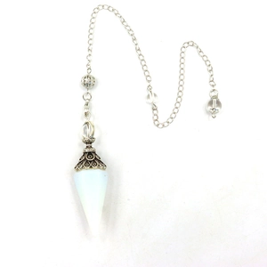 Macro shot of white crystal pendulum with vintage silver metal filigree and silver chain