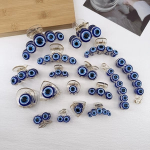 Transparent acrylic hair claw clips with blue evil eye pattern in various sizes and shapes