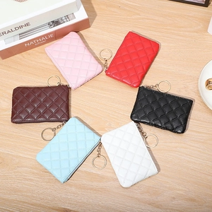 Quilted PU leather coin purses with keychains in six colors on a wooden table