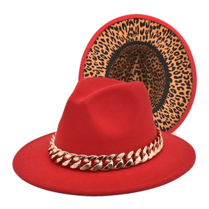 Detail of red fedora featuring a chunky gold chain and leopard print lining under the brim