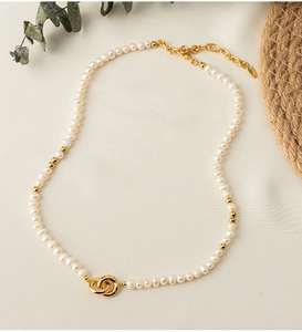 Detail of freshwater pearl choker necklace featuring interlocking gold metal rings